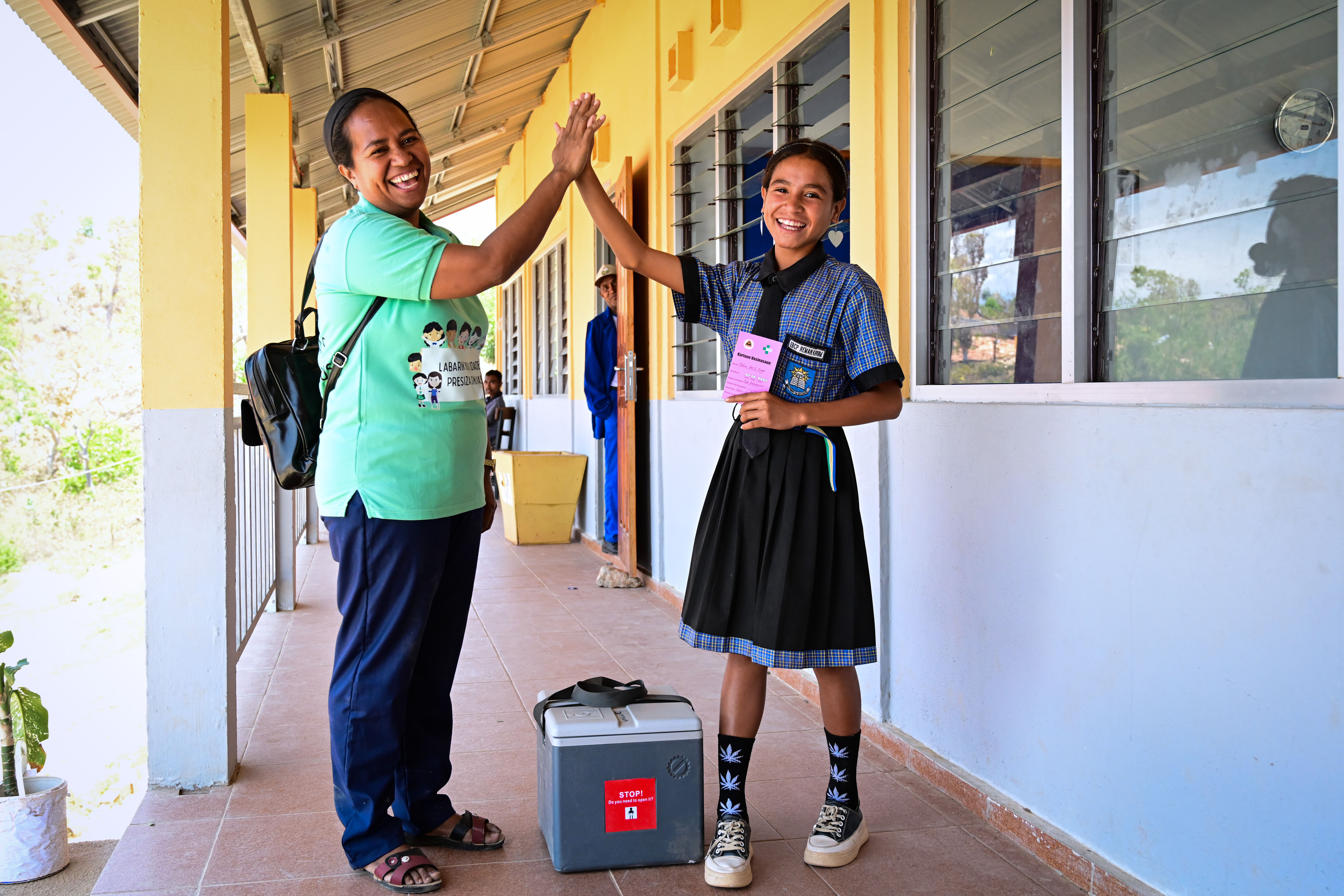 Vaccinator Zulmira Cabral gives a high fives to Eldina Rego after the vaccination.
